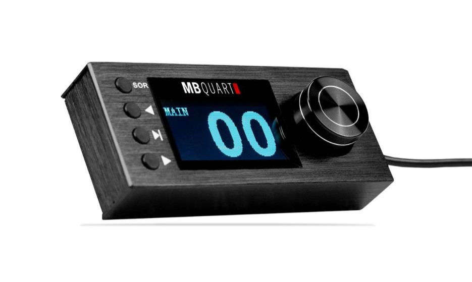 A black MB Quart audio controller featuring a digital display with a blue numeric readout, a knob for adjustment, and several control buttons.